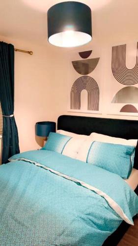 a bedroom with a bed with a blue comforter at Mo Apartment in Accrington