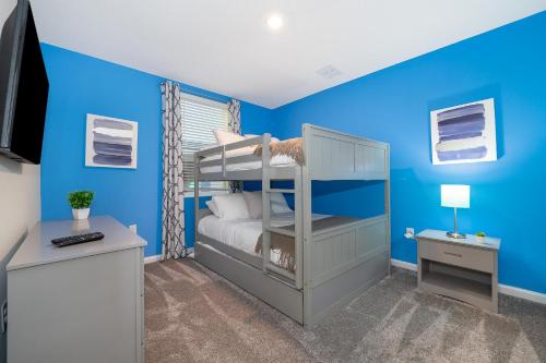 um quarto com paredes azuis e um beliche em 817JE CHAMPIONS GATE,CONDO + GAME ROOM em Kissimmee