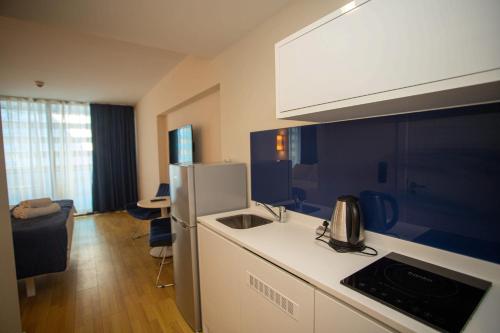 a kitchen with a sink and a refrigerator at ORBI CITY BATUMI AMAZlNG APARTMENT in Batumi