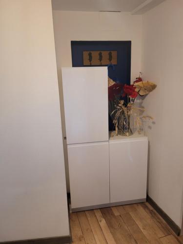 ein weißer Kühlschrank in einem Raum neben einer Wand in der Unterkunft Effet Mer, 4 etoiles, gîte de 80m2 in Dorlisheim