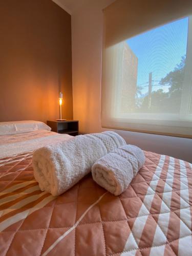 1 dormitorio con 1 cama con 2 toallas en Tranquilidad en el corazón de la ciudad en Posadas