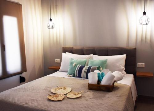 a bed with a tray of towels and hats on it at Olgas cozy home in Chania Town