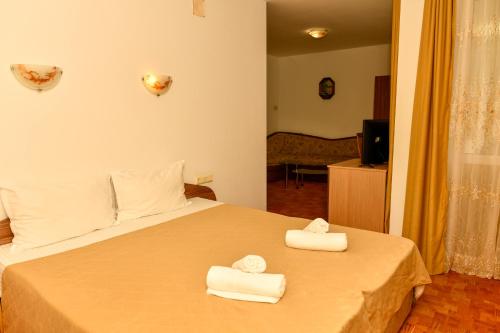 a bedroom with a bed with two towels on it at Blyan Family Hotel in Chiflik