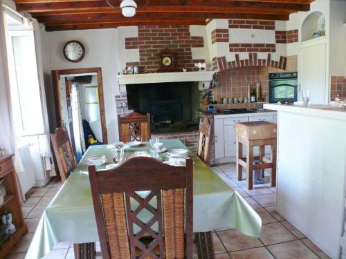 a kitchen with a dining table and a fireplace at Papillons B&B - beauty, comfort and peace 25 mins from Puy du Fou in Montournais