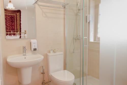 a bathroom with a toilet and a sink and a shower at Casa Do Peirão 