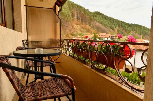 a balcony with a table and chairs and a view at Blyan Family Hotel in Chiflik