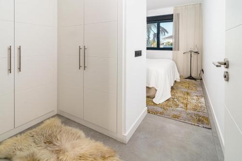 Cette chambre dispose d'armoires blanches et d'un tapis. dans l'établissement LAE131D- Apotel Estepona hills by Roomservices, à Estepona