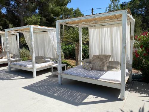 two white beds are sitting on a patio at Boutique Hotel CASA CARACOL - Apartments in Strandnähe, Salzwasserpool, Fotovoltaik, Adults Only in San Jose