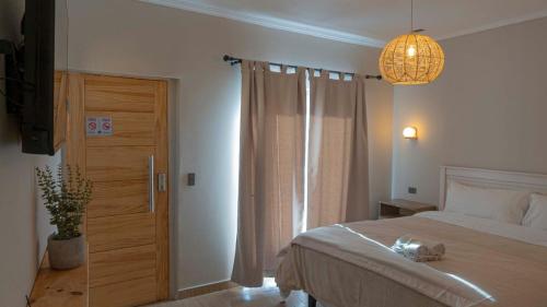 a bedroom with a bed and a chandelier at Hotel La Casona del Desierto in Huasco