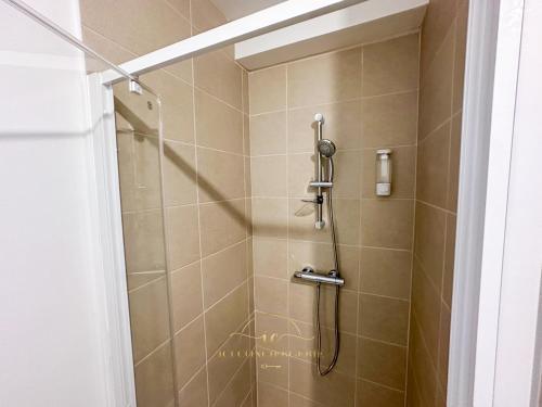 a shower in a bathroom with a glass door at Le Jardin Rambolitain - Terrasse et Parking in Rambouillet