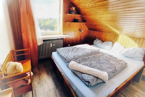 ein Schlafzimmer mit einem Bett in einem Zimmer mit einem Fenster in der Unterkunft Harz de luchs in Bad Harzburg