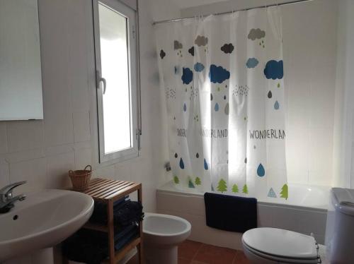 a bathroom with a toilet and a sink and a shower curtain at Casa con Jardín entre Toledo y Puy du Fou in Toledo