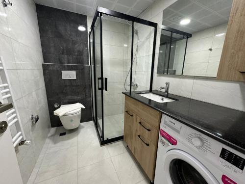 La salle de bains est pourvue d'une douche et d'un lave-linge. dans l'établissement Lara's Suite Antalya 10, à Antalya