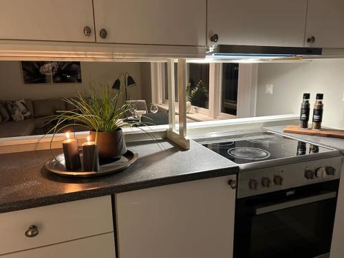 a kitchen with a stove and candles on a counter at Leilighet med strandbeliggenhet in Ramberg