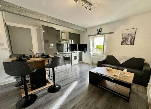 a living room with a couch and a table at ISVAL Wifi-Hyper Centre Cognac in Cognac