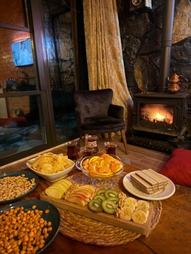 a table topped with different types of food and a fireplace at AYDER BUNGALOW - river view , Royal Bungalow Resorts in Çamlıhemşin