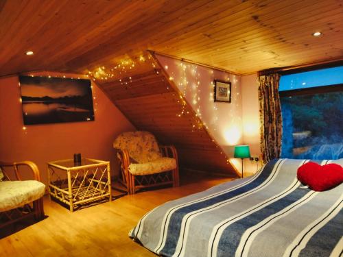 1 dormitorio con 1 cama, 1 silla y 1 ventana en Meadowsweet Forest Lodge en Fintown