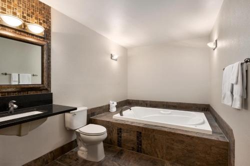 ein Badezimmer mit einer Badewanne, einem WC und einem Waschbecken in der Unterkunft Carrollton Hotel in Carroll