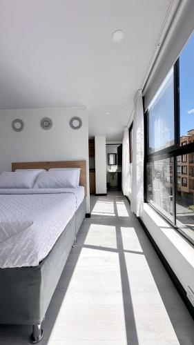 a bedroom with a bed and a large window at Loft 60 Movistar arena 403 in Bogotá