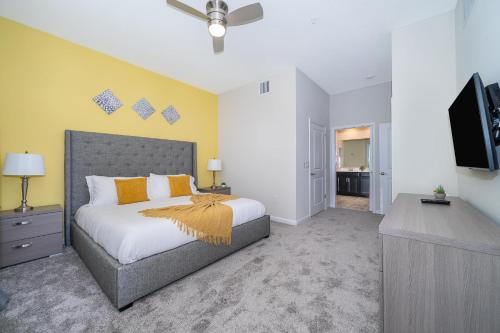 een slaapkamer met een bed en een flatscreen-tv bij 1147CR CHAMPIONS GATE,CONDO + GAME ROOM in Kissimmee