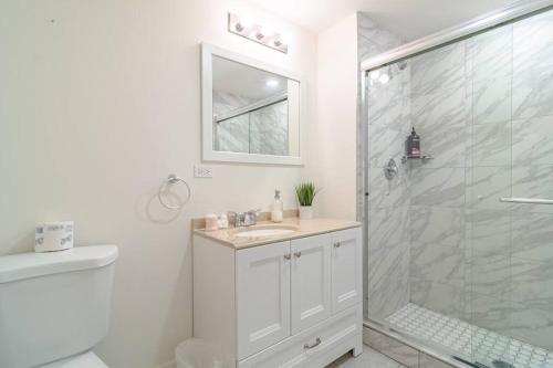 a white bathroom with a shower and a sink at McCormick Place 420 friendly 3BR/2BA with optional parking in Chicago