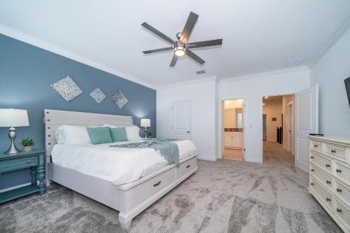 - une chambre avec un lit blanc et un ventilateur de plafond dans l'établissement 475RG ACROSS THE OCEAN 4 BEDROOMS & 5.5 BATHROOMS + POOL & SPA, à Melbourne Beach