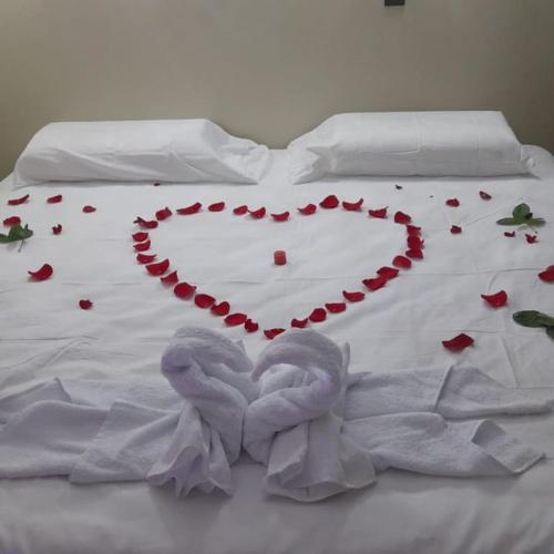 un letto bianco con un cuore fatto di rose di Hotel Amazon deluxe a Jaén