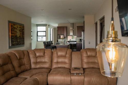 a brown couch in a living room with a kitchen at Casa departamento 4 hab rooftop in Arandas