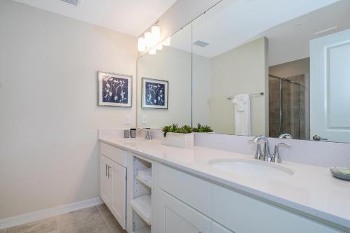 ein weißes Badezimmer mit 2 Waschbecken und einem großen Spiegel in der Unterkunft 3161-201RG STOREY LAKE, CONDO 3/2 LAKE VIEW in Kissimmee