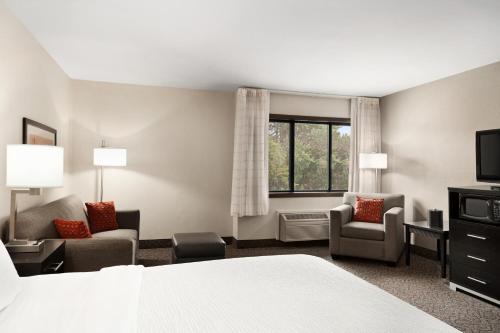 a hotel room with a bed and chairs and a window at Carrollton Hotel in Carroll