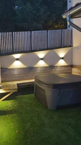 a backyard with a wooden bench with lights on it at La Loge des Volcans - Vue Puy De Dôme in Saint-Genès-Champanelle