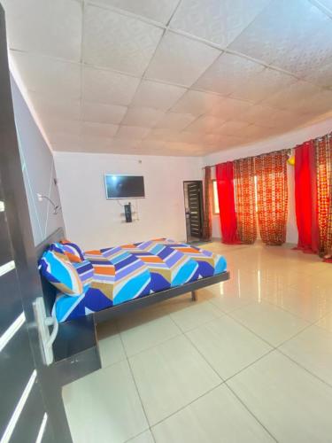 1 dormitorio con 1 cama y TV. en Villadeluxe3, en Abomey-Calavi