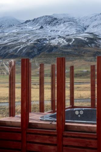 a view through a wooden fence of a snow covered mountain at Kornmúli in Búðardalur