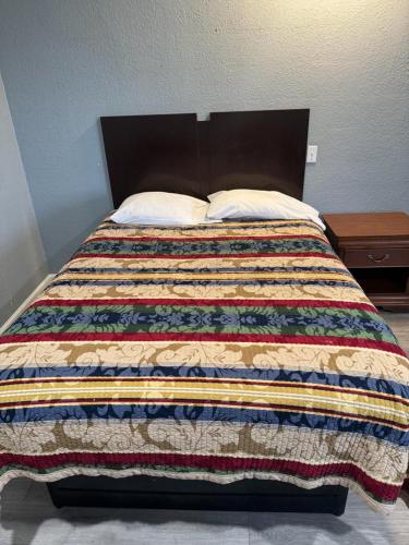 a bed with a quilt and two pillows on it at Midtown Lodge in Jacksonville