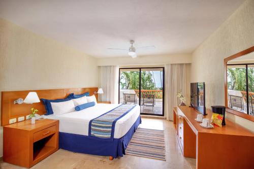 a hotel room with a bed and a balcony at Plaza Pelicanos Grand Beach Resort All Inclusive in Puerto Vallarta