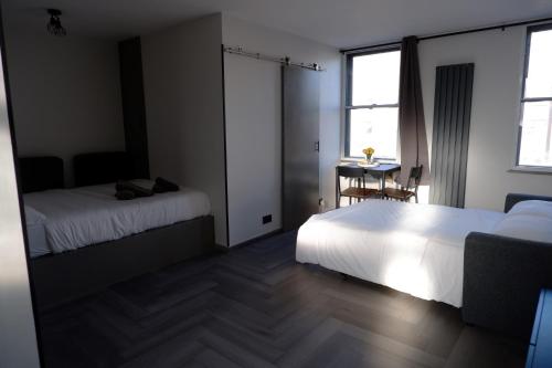 Cette chambre comprend 2 lits et une table. dans l'établissement Studio Suite in Pimlico/Victoria, à Londres