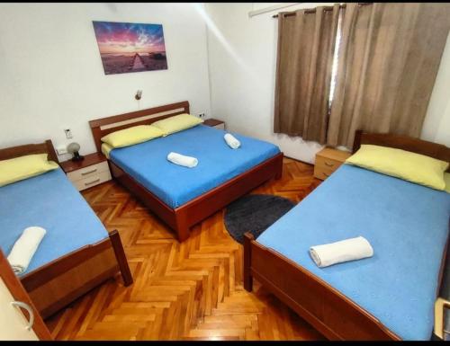 Duas camas num quarto com pisos em madeira em Manora Sucuraj one bedroom apartment em Sućuraj
