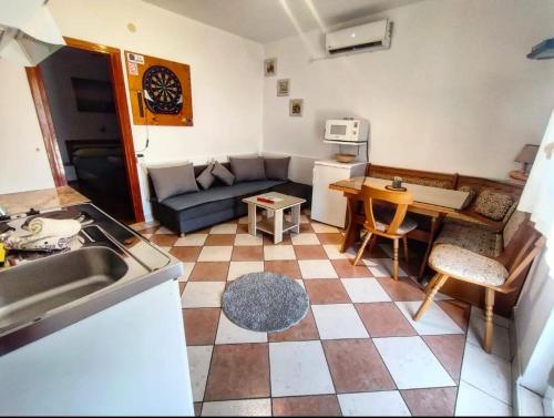 uma cozinha e sala de estar com um sofá e uma mesa em Manora Sucuraj one bedroom apartment em Sućuraj