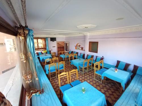 a dining room with blue tables and chairs at Hôtel Restaurant BOUGAFER in Oulad Akkou