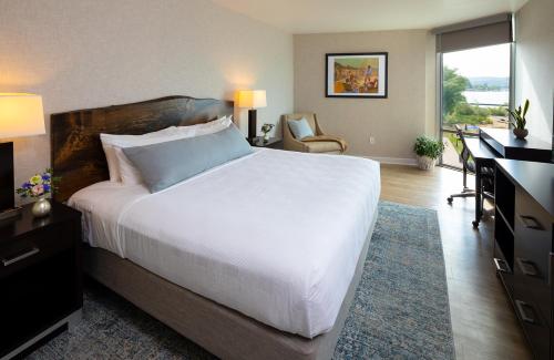a bedroom with a large white bed and a desk at Delamar Traverse City in Traverse City