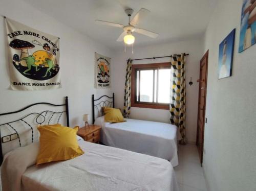een slaapkamer met 2 bedden en een plafondventilator bij Acogedor apartamento con vistas 80 m2 in Alcossebre