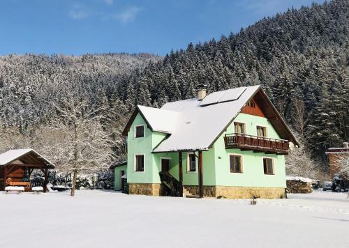 a house with a snow covered roof in the snow at VILLA LÚČKY in Lúčky