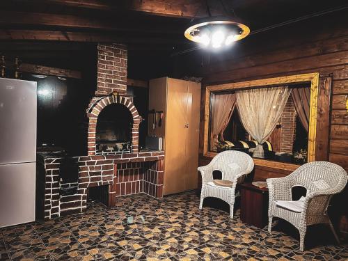 a kitchen with two chairs and a brick oven at Cabana Refugiul Montan Belis in Beliş