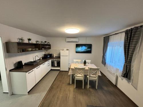 Szeglet Apartman في Andornaktálya: مطبخ وغرفة طعام مع طاولة وكراسي
