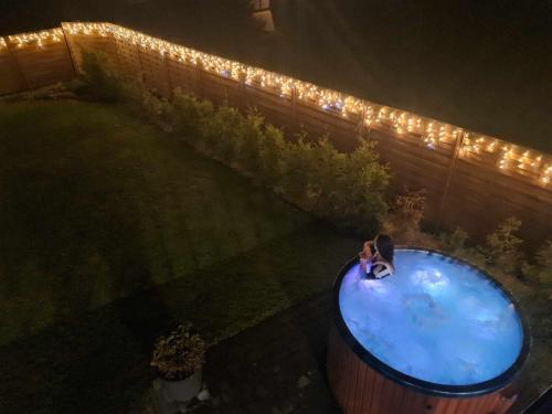 Eine Frau steht nachts in einer Wanne im Garten in der Unterkunft Domki u Duszy in Brenna
