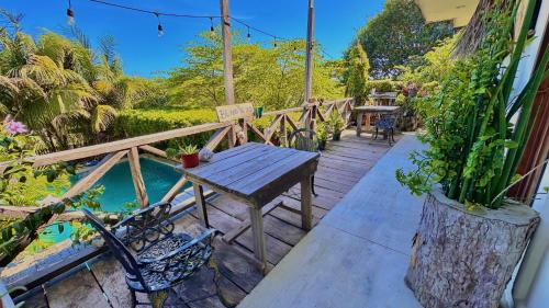 a wooden deck with a wooden table and chairs at Hotel Jaiba Mahahual - Adults Only in Mahahual
