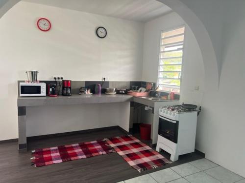 a kitchen with a counter and a sink and a microwave at Stay'N Go in Uturoa