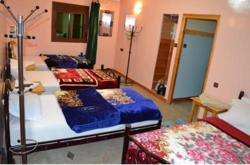 a room with three beds in a room at Hôtel Restaurant BOUGAFER in Oulad Akkou