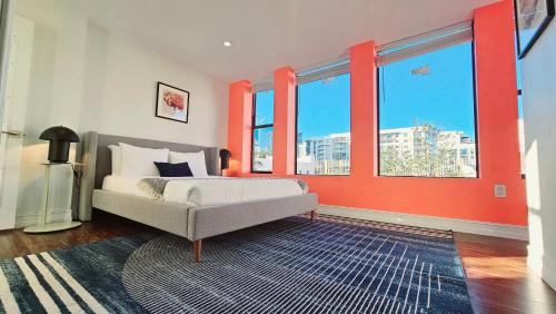 um quarto com paredes cor de laranja e uma cama com um tapete em The Lofts on Clematis 301 Downtown West Palm Beach em West Palm Beach