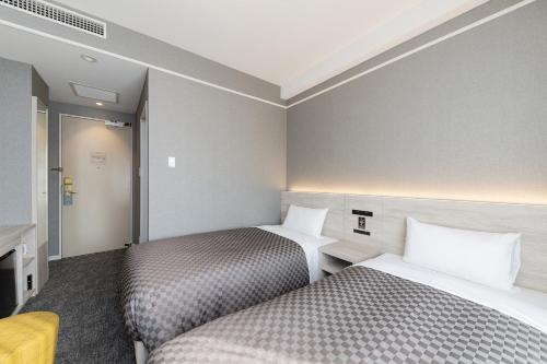 ein Hotelzimmer mit 2 Betten und einem TV in der Unterkunft The One Five Garden Kurashiki - Vacation STAY 40165v in Kurashiki